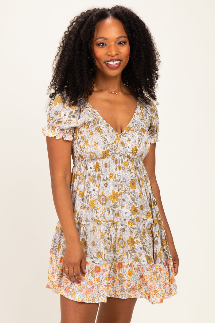 woman wearing a floral print short sleeve dress with a v-neck and ruffled hem in light colors