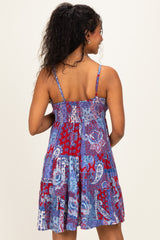 woman wearing a colorful patterned maternity sundress with adjustable spaghetti straps and a flowy skirt