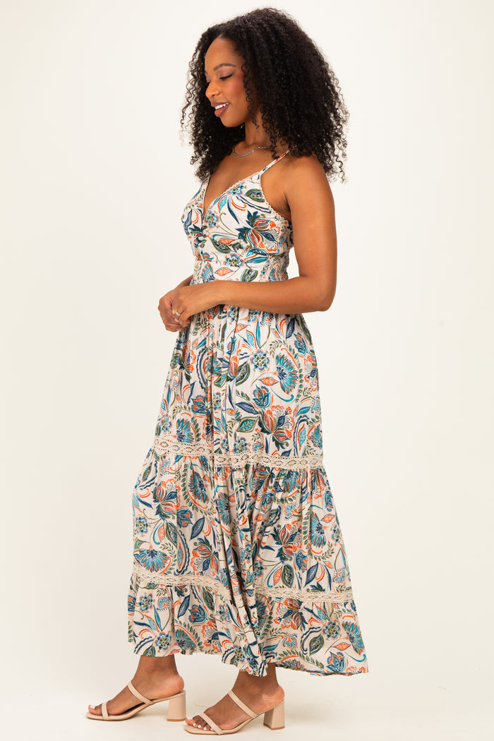 woman wearing a floral print maxi dress with a tiered skirt and spaghetti straps