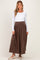 woman wearing a white long sleeve top and a brown maxi skirt, showcasing a flattering maternity style