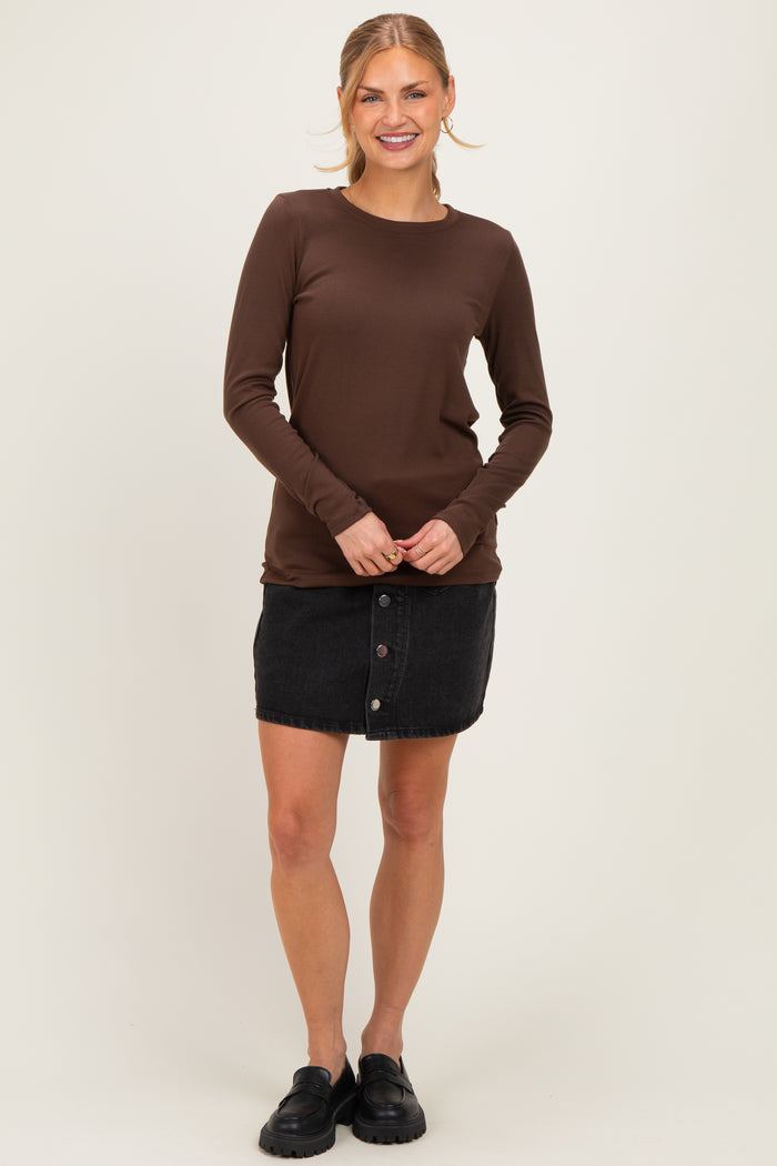 woman wearing a brown long sleeve top and a black denim button-up skirt