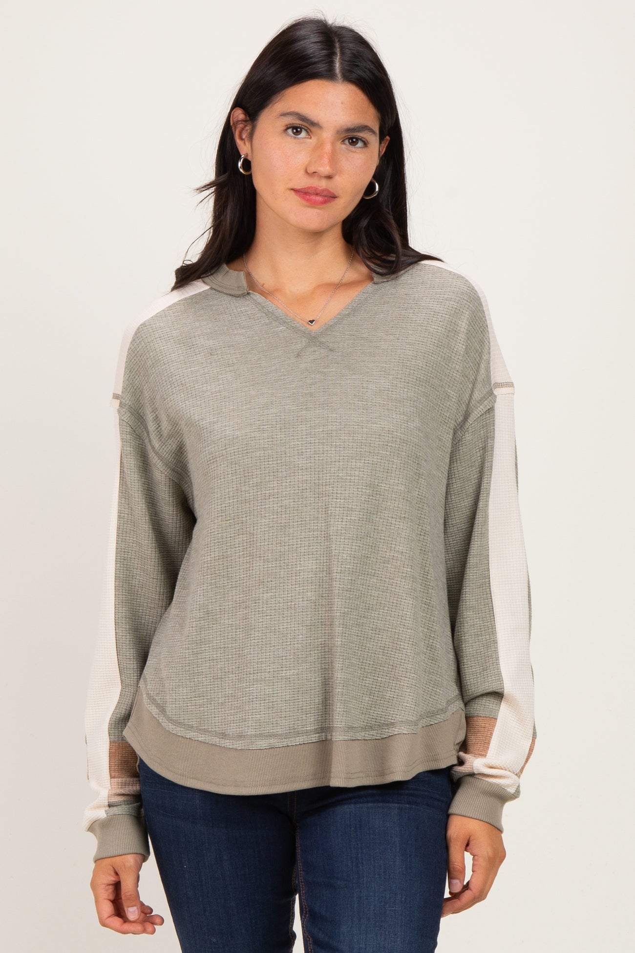 woman wearing a green and beige color-blocked long sleeve hoodie with a loose fit and v-neckline