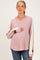 woman wearing a pink maternity hoodie with color-blocked sleeves and holding her baby bump