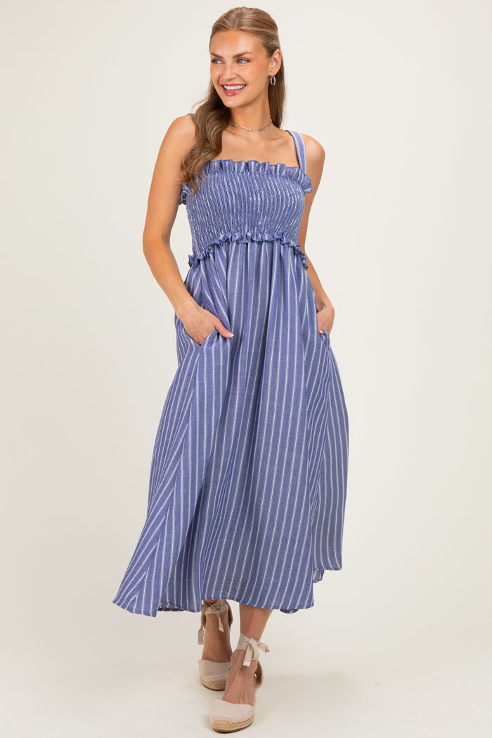 woman wearing a blue and white striped maxi dress with a smocked bodice and pockets, styled with espadrille wedges