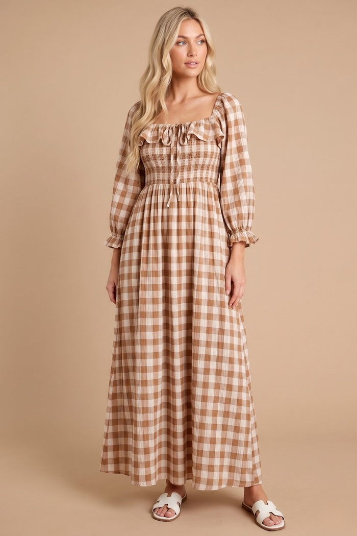 woman wearing a long brown gingham maxi dress with a square neck and puff sleeves