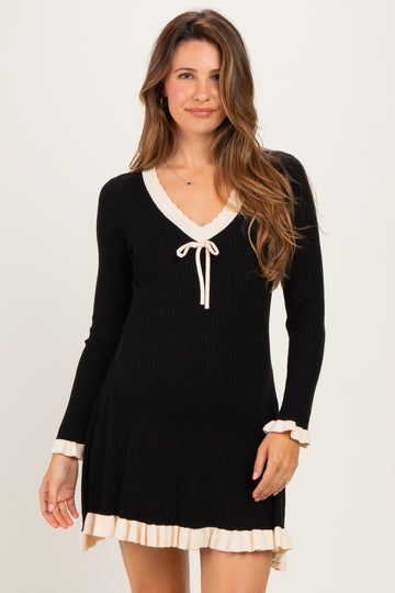 woman wearing a black long sleeve maternity dress with a v-neck and cream ruffle details