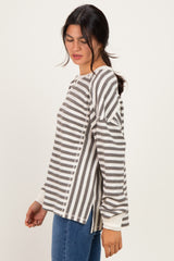 woman wearing a gray and white striped long sleeve top with side slits and a relaxed fit