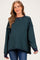 woman wearing a striped green and navy maternity sweater with a relaxed fit and side slits