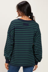 woman wearing a navy and green striped oversized sweatshirt with long sleeves and a relaxed fit from the back