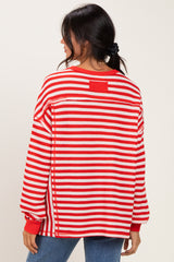 woman wearing a red and white striped oversized sweater with a relaxed fit and crew neckline
