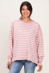 woman wearing a pink and white striped oversized sweatshirt with a relaxed fit and long sleeves