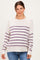 woman wearing a cream and purple striped maternity sweater with a relaxed fit and long sleeves