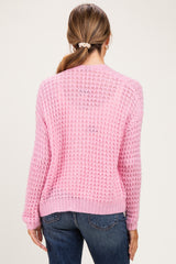 woman wearing a pink knitted maternity sweater with a relaxed fit and back view, paired with jeans