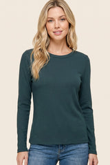 woman wearing a dark teal long sleeve ribbed top with a rounded neckline and relaxed fit