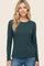 woman wearing a dark teal long sleeve ribbed top with a rounded neckline and relaxed fit