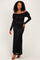 woman wearing a black off-the-shoulder lace maxi dress with long lace sleeves and a tie detail on the bust