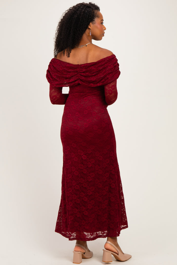woman wearing a burgundy lace off-the-shoulder maxi dress with a fitted bodice and flowing skirt, seen from the back