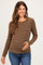 woman wearing a brown and gray striped maternity top with long sleeves and holding her baby bump