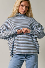 woman wearing a light blue and navy striped turtleneck sweatshirt with oversized sleeves and relaxed fit