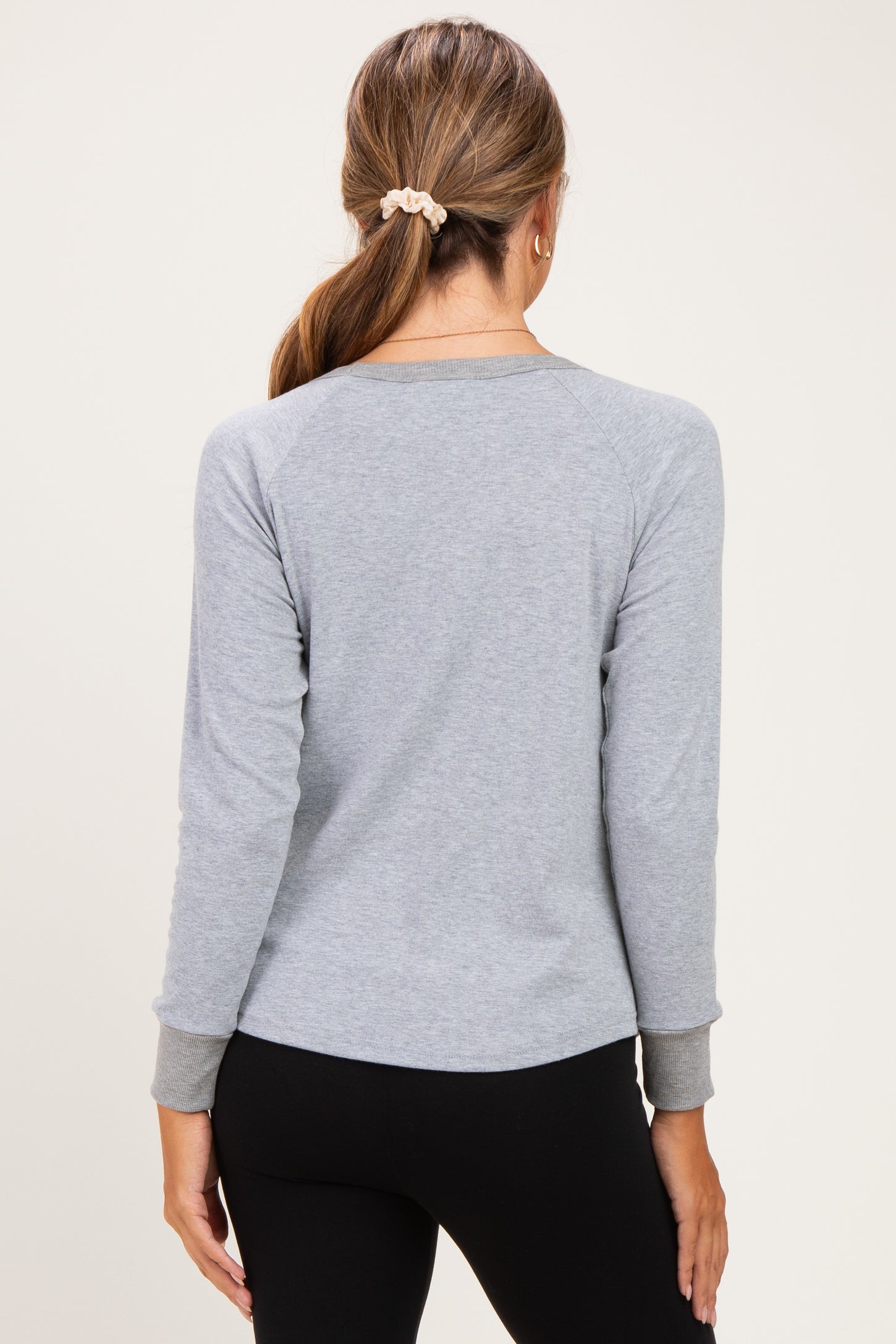 woman wearing a gray long sleeve maternity top with a relaxed fit, shown from the back