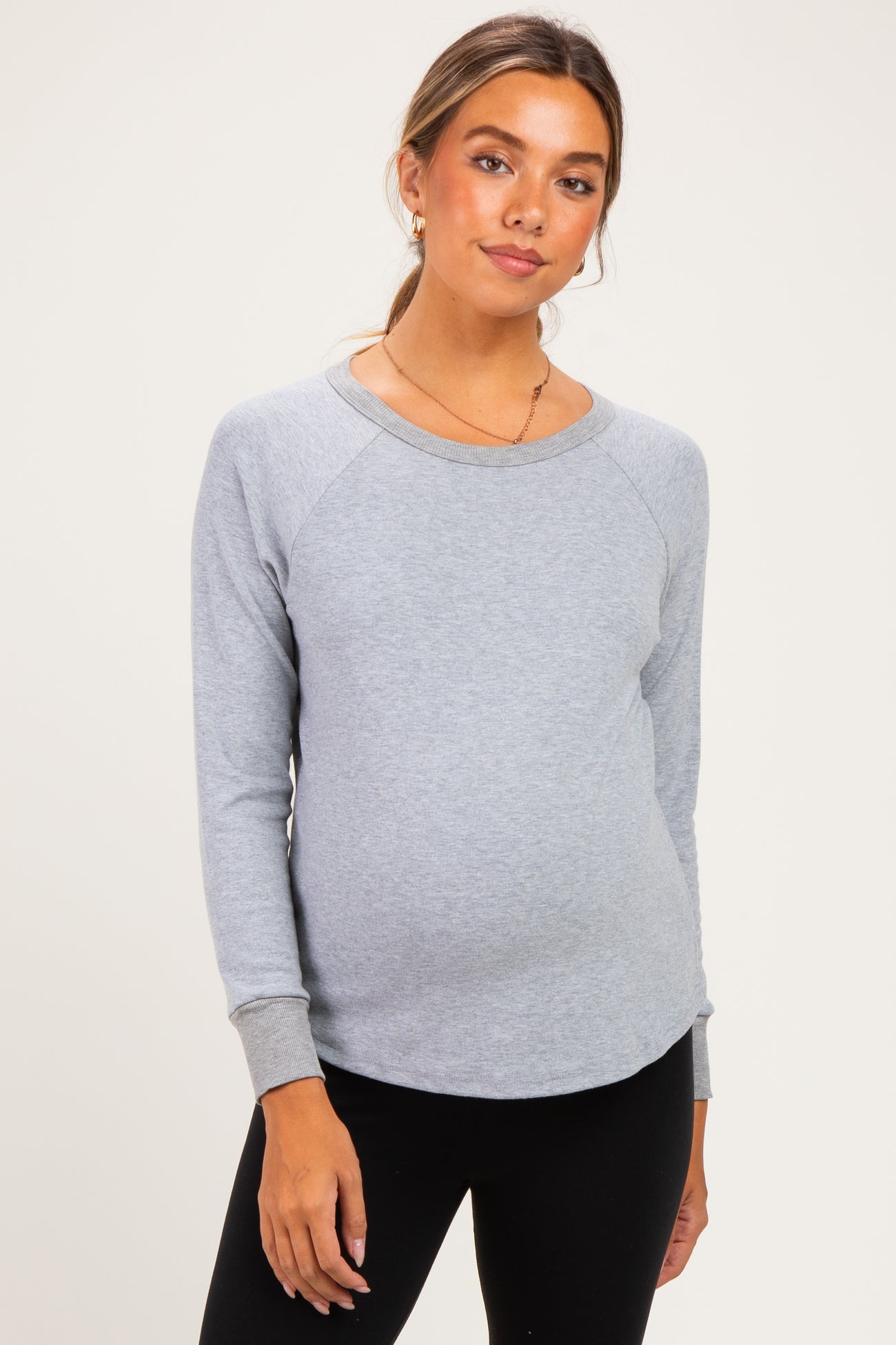 woman wearing a gray maternity sweatshirt with raglan sleeves and a visible baby bump