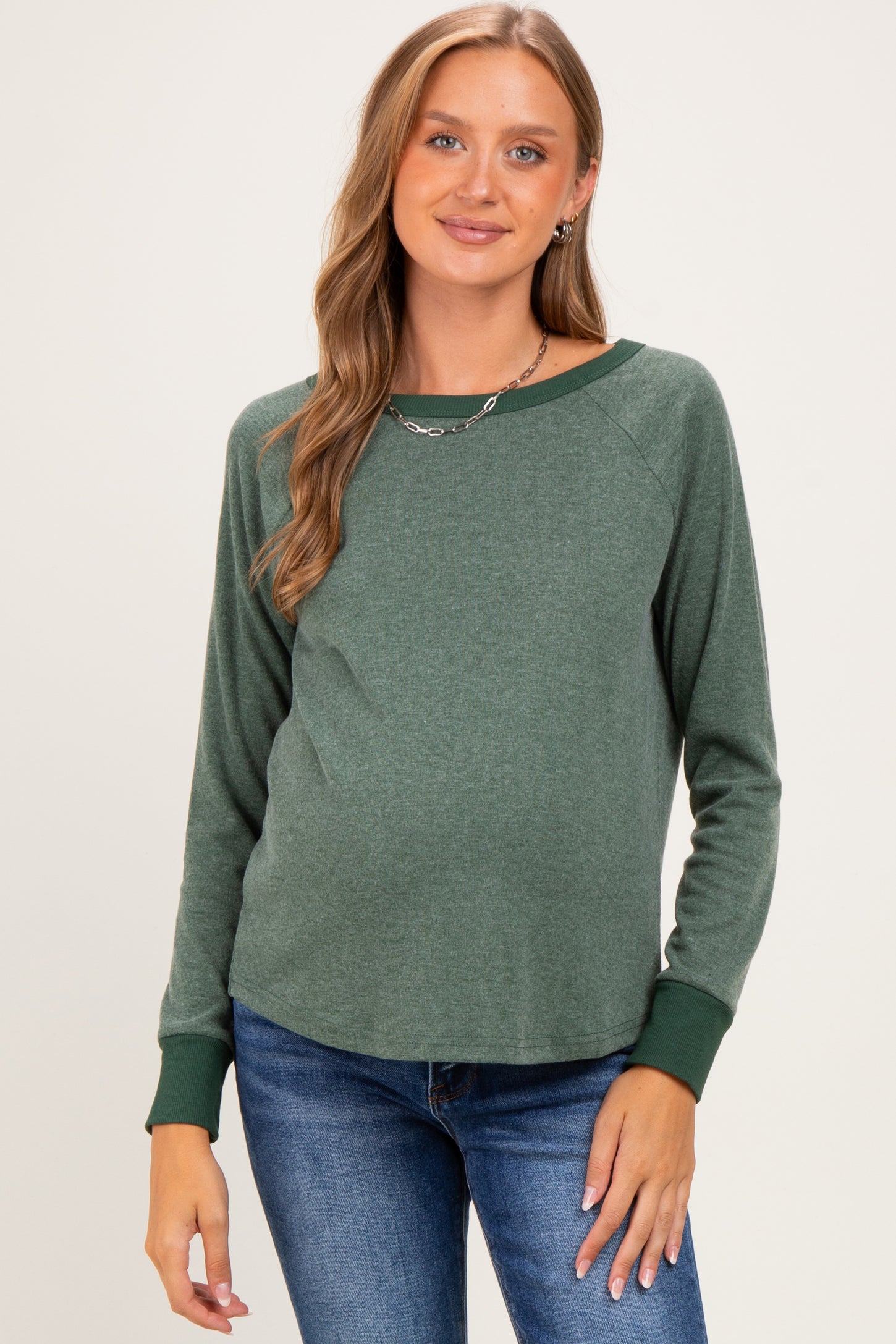 woman wearing a green maternity long sleeve top with a relaxed fit and a visible baby bump