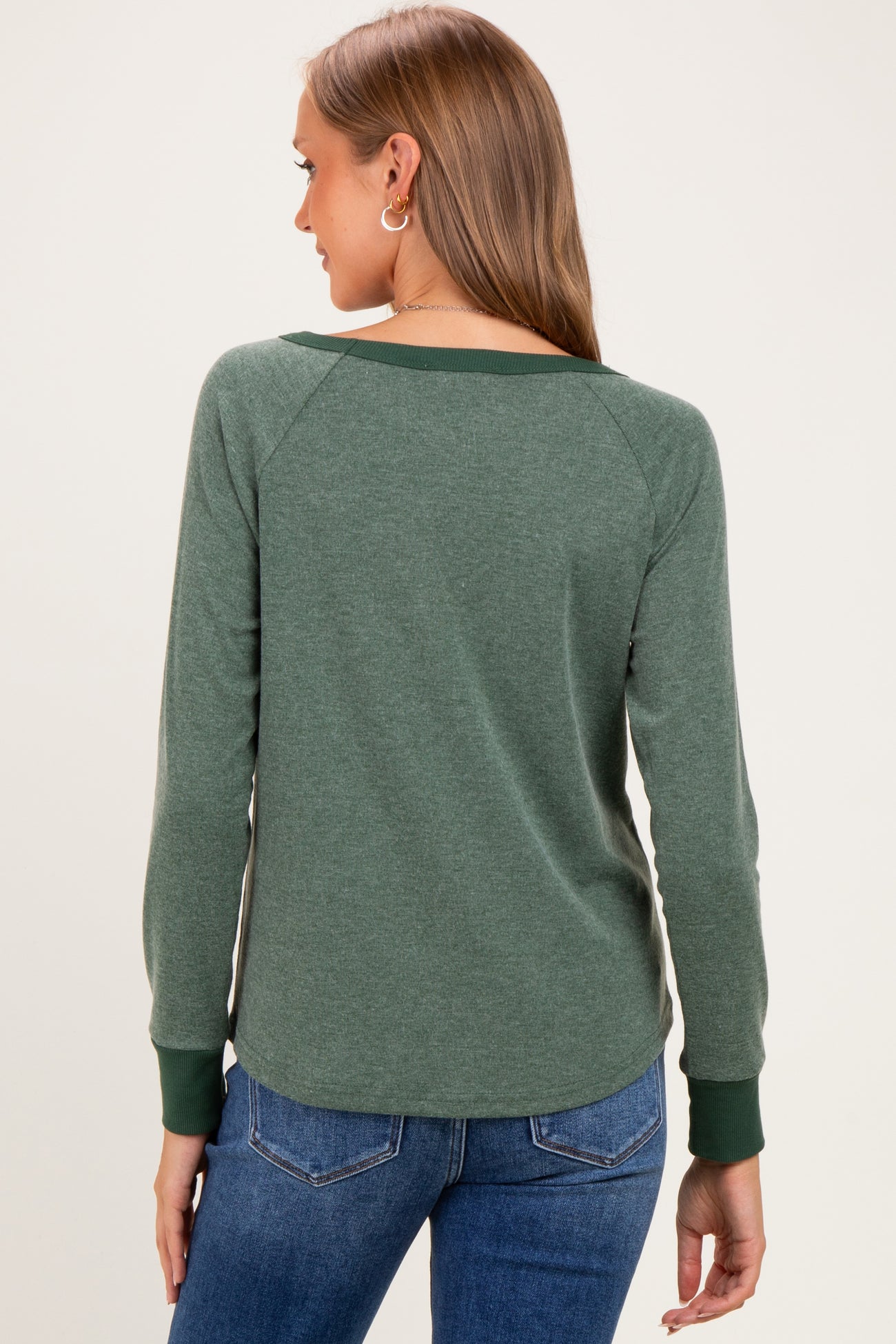 woman wearing a green long sleeve maternity top with raglan sleeves and a slight v-neck, seen from the back