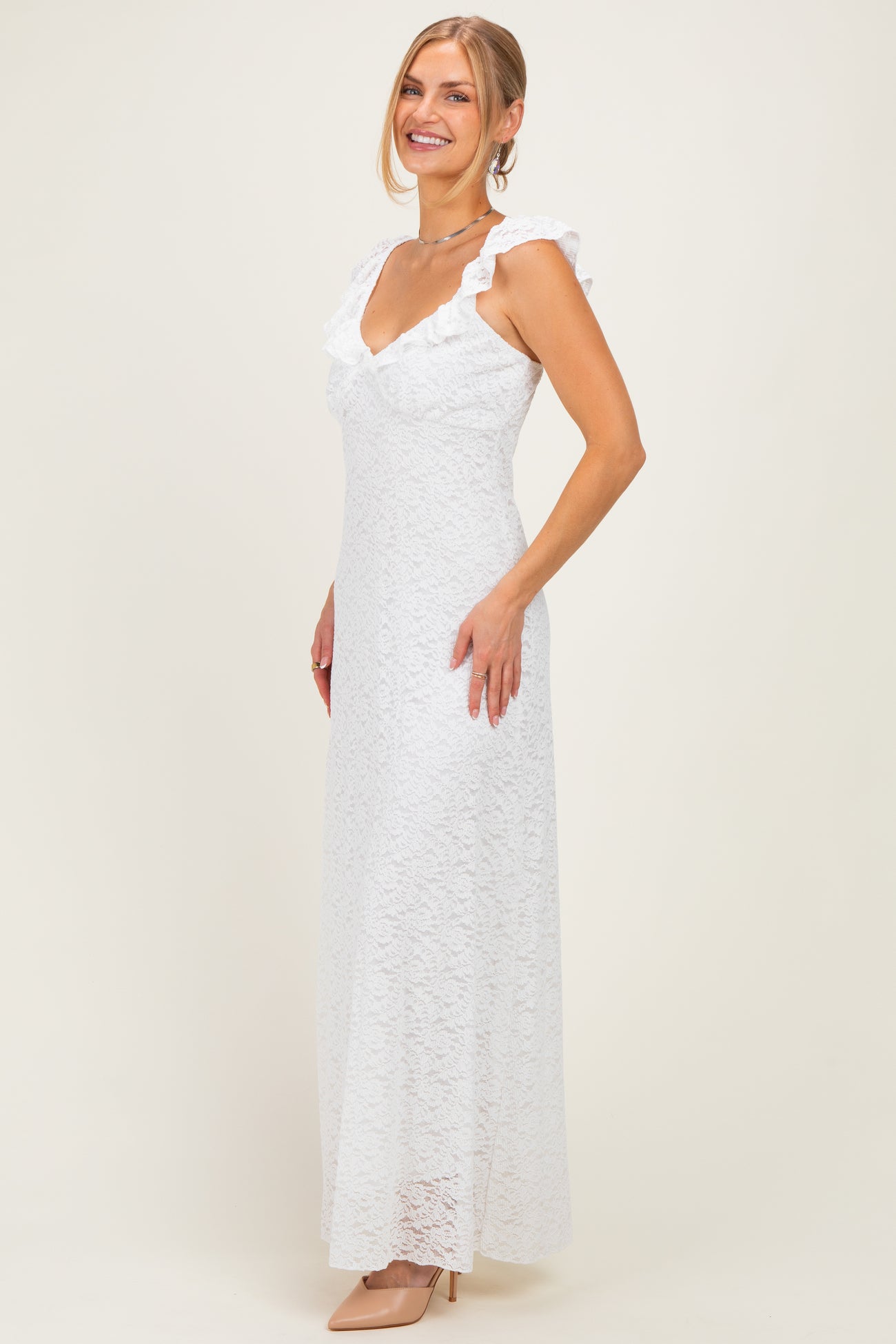 woman wearing a white lace maxi dress with ruffled sleeves and a deep v-neckline