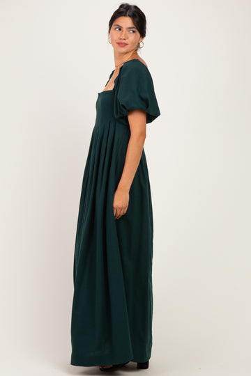 woman wearing a dark green maxi dress with puffed short sleeves and a square neckline