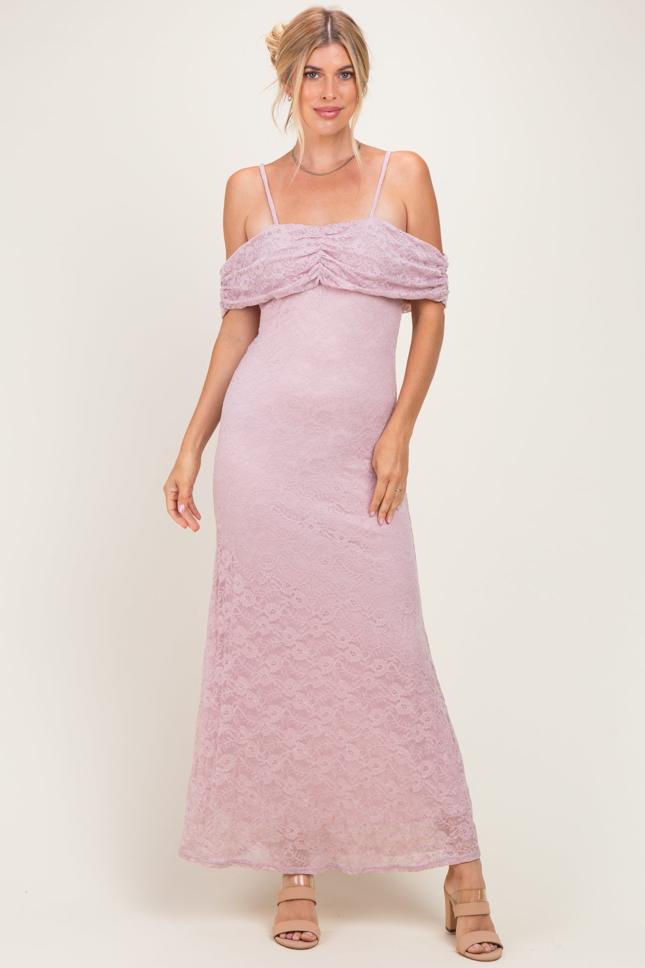 woman wearing a light pink off-the-shoulder lace maxi dress with ruched detailing and thin straps