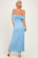 woman wearing a light blue lace maxi dress with off-the-shoulder sleeves and a fitted silhouette