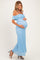 woman wearing a light blue off-the-shoulder lace maternity dress and cradling her baby bump