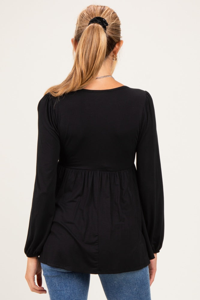 woman wearing a black long sleeve maternity top with a gathered waist and back view, styled with blue jeans