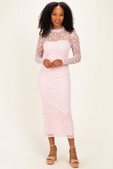 woman wearing a light pink long sleeve lace dress with floral pattern and a fitted silhouette