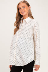 woman wearing a white maternity shirt with black polka dots and a visible baby bump