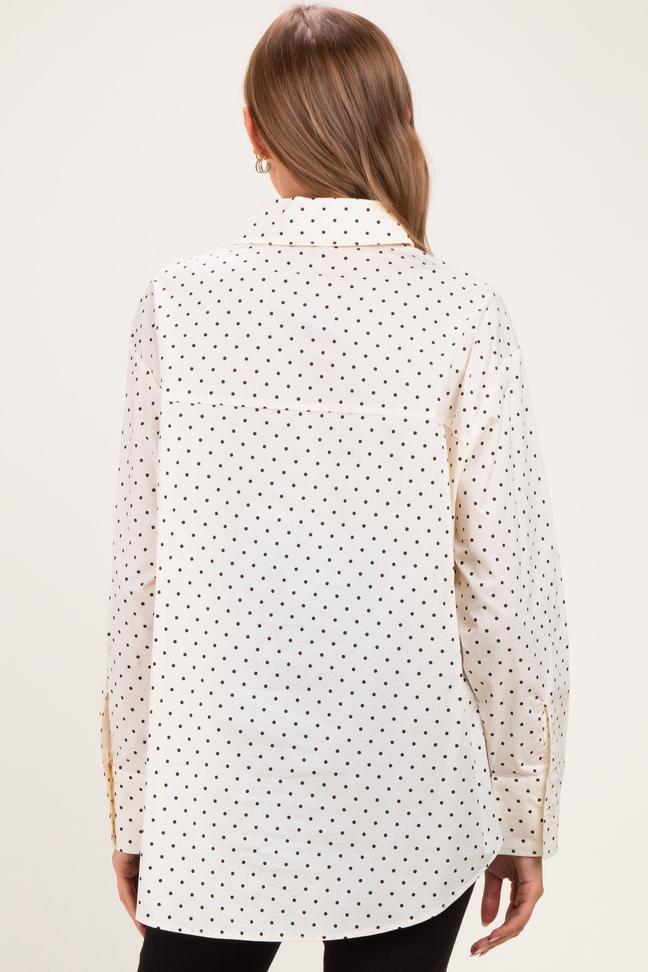 maternity wear in white with black polka dots, long sleeve button-up shirt seen from the back