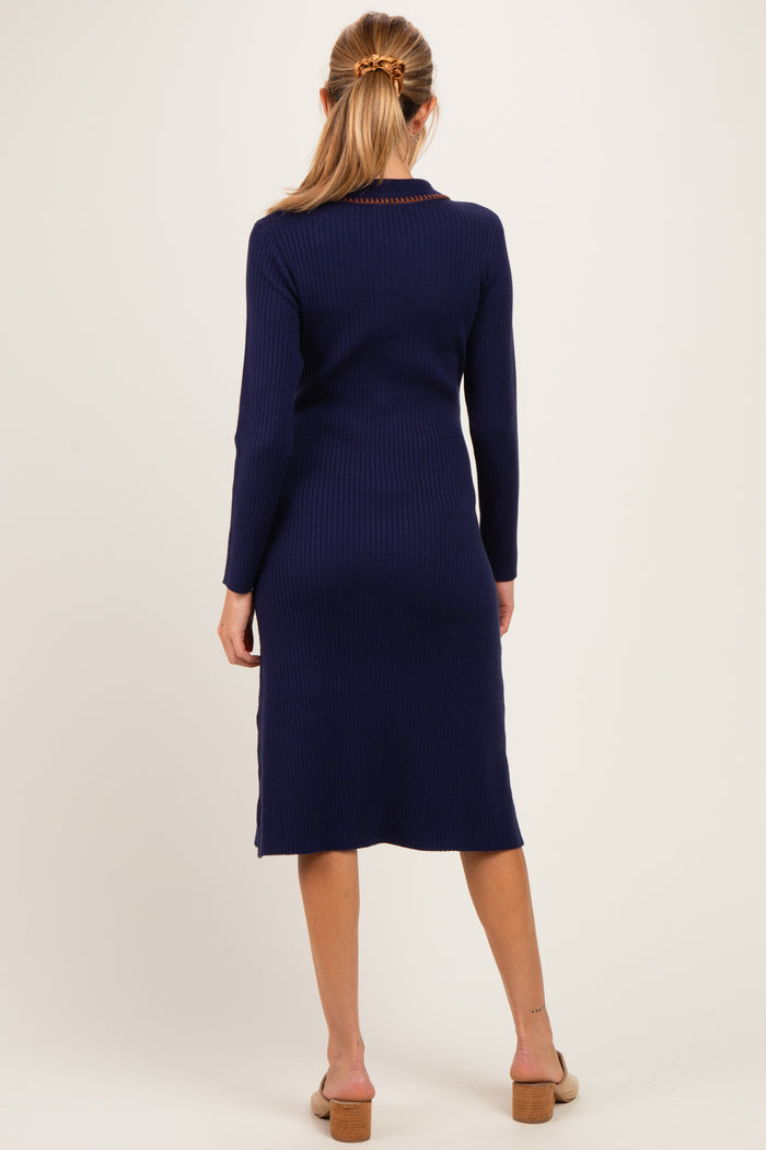 woman wearing a navy blue ribbed long sleeve maternity dress with a mid-calf length and a fitted silhouette