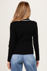 woman wearing a black ribbed maternity sweater with a contrast collar, viewed from the back