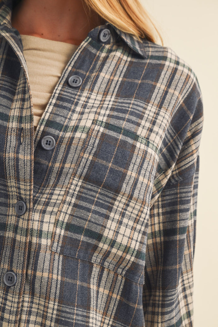 woman wearing a blue and beige plaid flannel shirt with a chest pocket and button-up detail