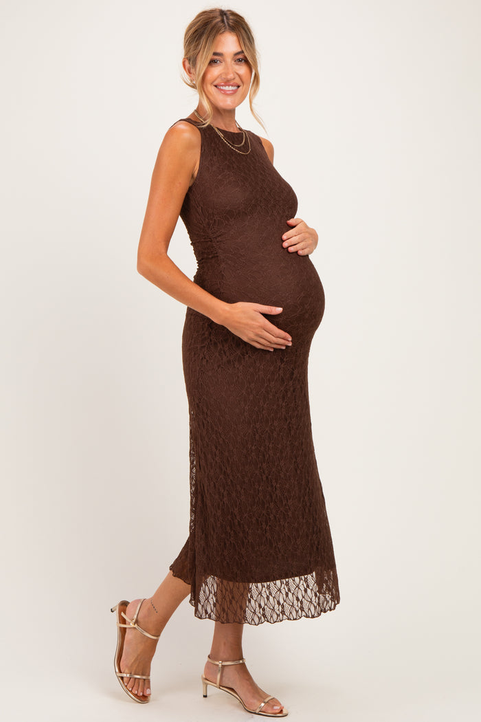 woman wearing a brown lace maternity dress and holding her baby bump