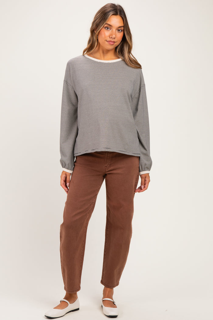 woman wearing a gray striped long sleeve maternity top and brown maternity pants with a relaxed fit