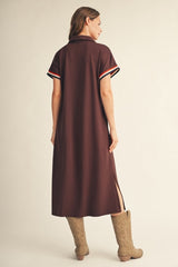 woman wearing a brown short sleeve collared dress with side slits and contrasting striped details on sleeves