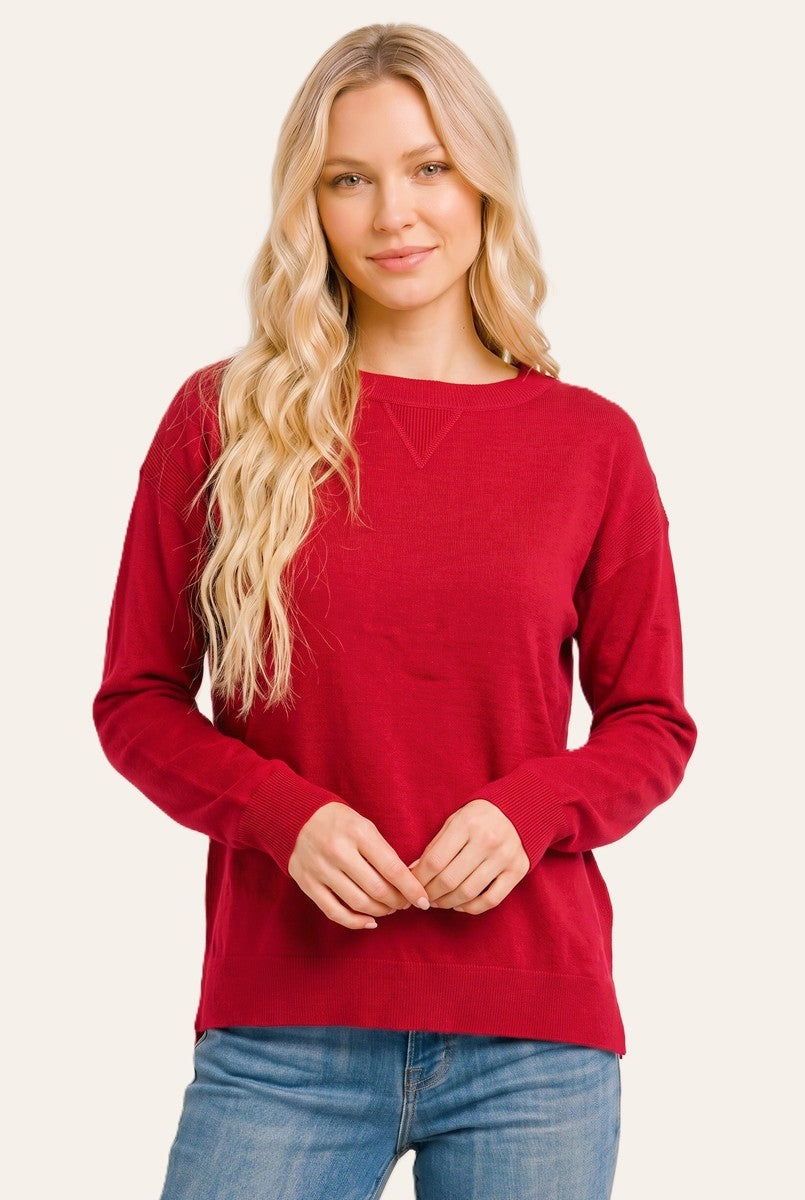 woman wearing a red long sleeve sweater with a relaxed fit and crew neckline, paired with blue jeans