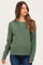 woman wearing a green maternity sweater with a relaxed fit and long sleeves, showing her baby bump