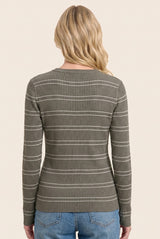 woman wearing a green ribbed long sleeve top with white stripes, seen from the back