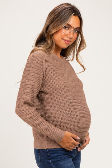 woman wearing a brown knitted maternity sweater and holding her baby bump