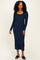 woman wearing a navy long sleeve ribbed dress with a scoop neckline and black slide sandals