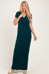 woman wearing a dark teal short sleeve maxi dress with a twisted front detail and a relaxed fit