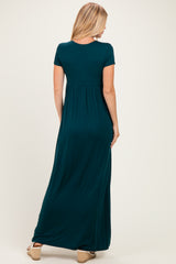 woman wearing a dark green short sleeve maxi dress, shown from the back with a flowy fit and a high waist seam