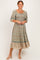 woman wearing a floral print mid-length dress with a smocked bodice and puff sleeves